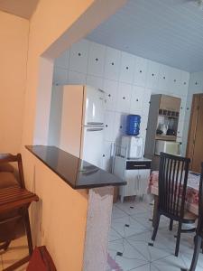 uma cozinha com um balcão e um frigorífico em Casa bom espaço para passar suas férias em Matinhos