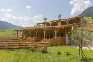 a wooden house in the middle of a field at Chalet Wiesenglück in Valle Di Casies