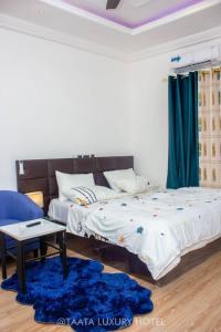- une chambre avec 2 lits et un tapis bleu dans l'établissement TAATA LUXURY HOTEL YENDI, à Yendi