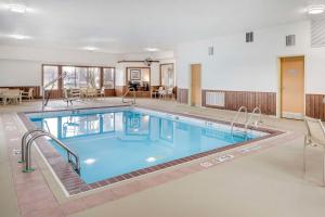 a pool in the middle of a building with tables and chairs at Best Western Celina in Celina