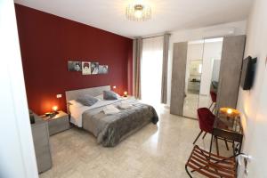 1 dormitorio con cama y pared roja en Bed and Breakfast Donna Maria, en Bari