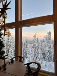 a window with a view of snow covered trees at Aamunkoi Skyview Villas A in Syöte