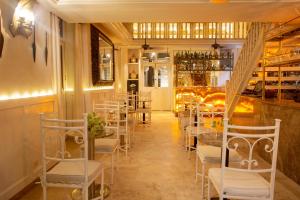un restaurante con mesas y sillas blancas y un bar en Leones de Alba Hotel Boutique, en Cartagena de Indias