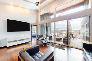 sala de estar con TV y ventana grande en Spokane River Retreat, en Coeur d'Alene