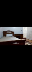 - une chambre avec un lit en bois et un bureau dans l'établissement تراس سموحه - بيتك يطل علي نادي سموحه, à Alexandrie