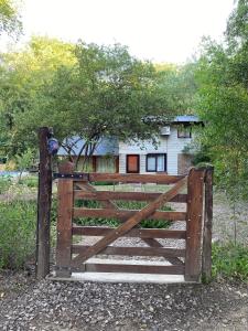 een houten poort voor een huis bij Complejo Jardín de Olmos in Villa Giardino