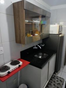 eine kleine Küche mit Spüle und Herd in der Unterkunft Apartamento no Bessa in João Pessoa