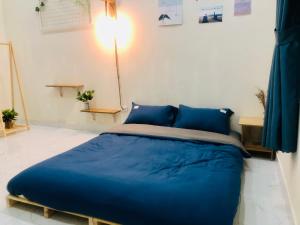 duże łóżko w pokoju z niebieskimi poduszkami w obiekcie Stella's Home w Duong Dong