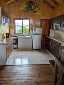 uma cozinha com electrodomésticos brancos e paredes de madeira em Cabañas Llepu em Linares