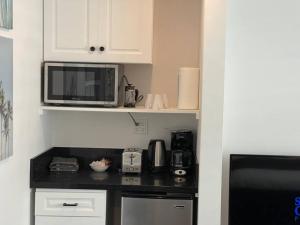 a kitchen with a counter with a microwave and appliances at House on The Beach in Los Angeles