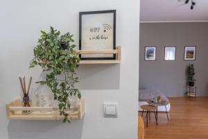 a living room with a plant on a wall at Old Town's Legend: City center condo with balcony in Maribor