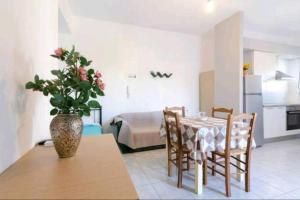 a dining room with a table and a vase with flowers at SUN Studio Pitsidia-Matala in Pitsidia +7 photos