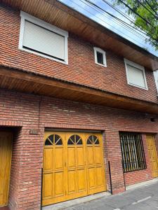 een bakstenen gebouw met twee houten garagedeuren bij Habitaciones Individuales Boulogne in Boulogne