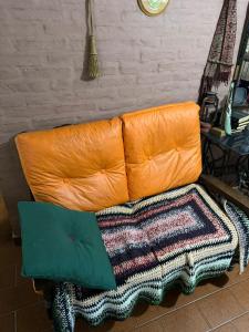 een oranje bank met een tapijt op de vloer bij Habitaciones Individuales Boulogne in Boulogne