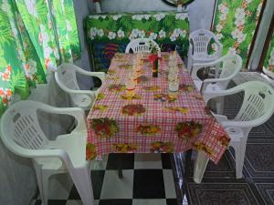 a table with white chairs and a red and white table cloth at Appartement de Charles in Loméméti