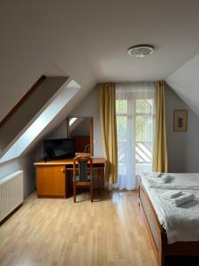 a bedroom with a desk and a bed and a desk at Aranykert Vendégház in Eger +49 photos