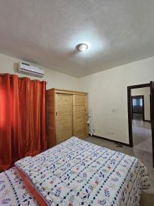 a bedroom with a bed and orange curtains at DALAL TERANGA in Dakar