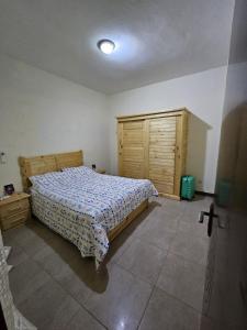 a bedroom with a bed and a wooden cabinet at DALAL TERANGA in Dakar