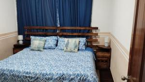 a bedroom with a bed with a blue comforter and pillows at Departamento Céntrico y cerca del Foro Sol in Mexico City