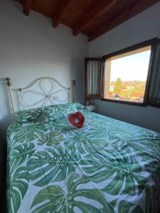 Un dormitorio con una cama con una flor roja. en El escondite de Torazo, en Torazo