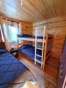 een slaapkamer met 2 stapelbedden in een blokhut bij Cabañas Llepu in Linares