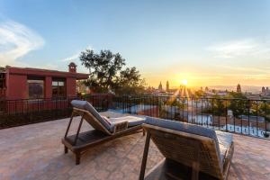 a balcony with a chair and a view of the city at Casa Almira 5BR Luxury Home with Pool, Hot Tub & Rooftop in San Miguel de Allende