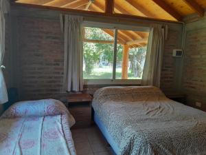 1 dormitorio con cama y ventana. en Entre Maitenes en Lago Puelo