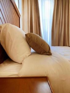 2 almohadas sentadas encima de una cama en Mini VELLA ALJWHARA en Al Ḩammām