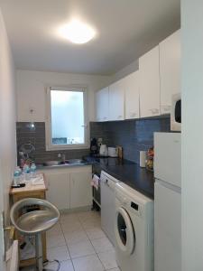 a kitchen with a washing machine and a window at BIG logement , Stade de France à pied, PARIS, métro , parking gratuit in Saint-Denis
