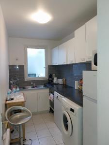 a kitchen with a washing machine and a window at BIG logement , JO2024, stade de France, PARIS, métro , parking gratuit in Saint-Denis