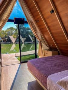 1 dormitorio con cama y ventana grande en RIO HOTEL Y GLAMPING en Jalpan