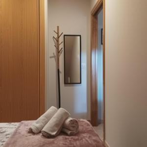 um quarto com um espelho e uma toalha numa cama em Ático en Carril con vistas al mar em Vilagarcía de Arousa