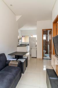 uma sala de estar com um sofá e uma mesa em Casa nova condomínio fechado Praia Grande SP em Solemar