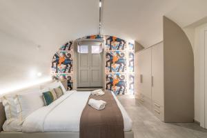 - une chambre avec un grand lit et un mur orné d'une fresque murale dans l'établissement Casa Spada Rooms, à Cagliari