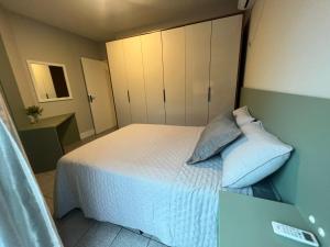 a bedroom with a bed with white sheets and pillows at BETARA in Florianópolis