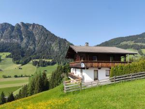 a house on a hill with mountains in the background at Chalet Mountain View in Alpbach