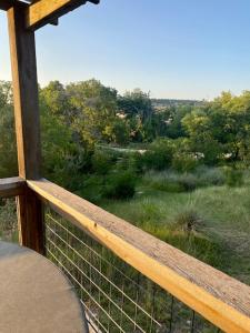 a porch with a view of a field and trees at City on a Hill at Spring Creek in Fredericksburg