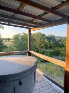 a porch with a bed on a wooden deck at City on a Hill at Spring Creek in Fredericksburg