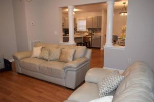 a living room with two couches and a kitchen at Home In Greenville 4 bedrooms, 4 beds, 2 baths in Greenville