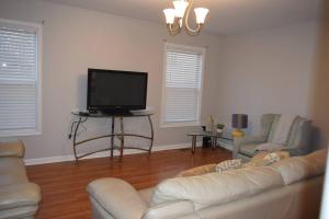 a living room with a couch and a flat screen tv at Home In Greenville 4 bedrooms, 4 beds, 2 baths in Greenville