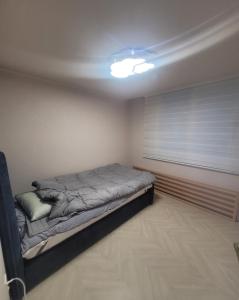 een slaapkamer met een bed in een kamer met een raam bij Gyeongdo CC and Ocean view in Yeosu