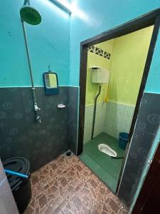 Baño pequeño con aseo y espejo en Homestay Hjh Rokiah, F.Tementi, 