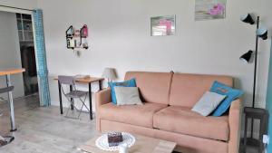 - un salon avec un canapé brun et une table dans l'établissement a lovely nest, à Bussy-Saint-Georges