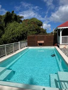 een zwembad met blauw water in een achtertuin bij Kaz Raphitou in Bouillante