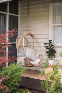 a wicker swing hanging from a porch at Benambra Cottage c1860 - PET FRIENDLY in Queenscliff