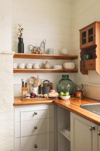 a kitchen with white cabinets and a counter top at Benambra Cottage c1860 - PET FRIENDLY in Queenscliff