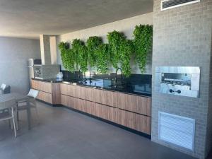 a kitchen with a counter with plants on the wall at Apartamento em Ponta Verde in Maceió