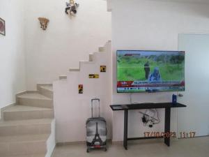 a living room with a staircase with a television and a table at Brisa de Mar in El Ojito