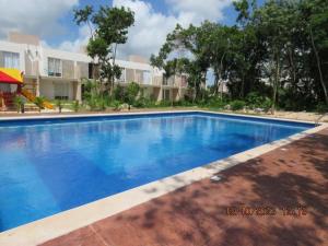 a large blue swimming pool in front of a building at Brisa de Mar in El Ojito