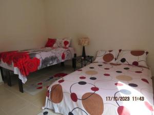 a bedroom with two beds with red and brownitures at Brisa de Mar in El Ojito